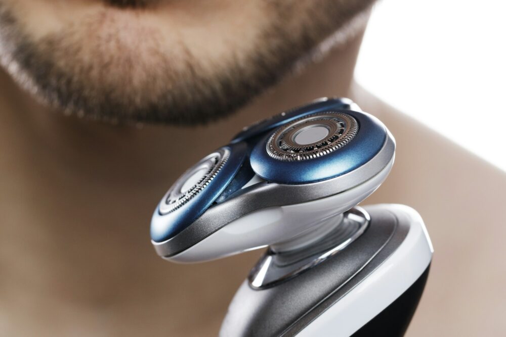 Close up of male chin and modern electric shaver